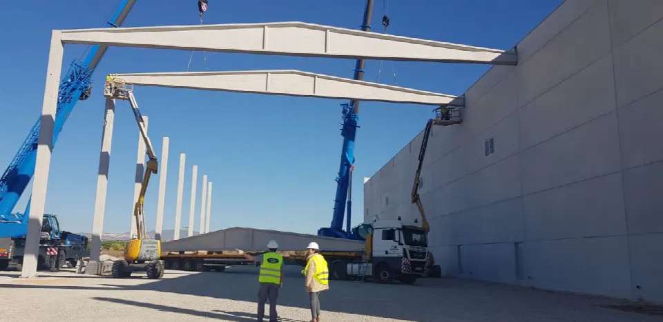 Montaje con grúas de una viga prefabricada en una nave de Fortuna (Murcia)